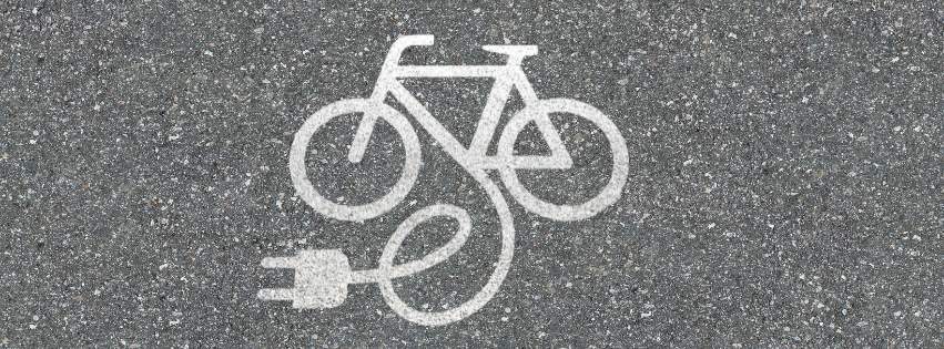 White pavement marking of a bicycle connected to an electrical plug, indicating an e-bike